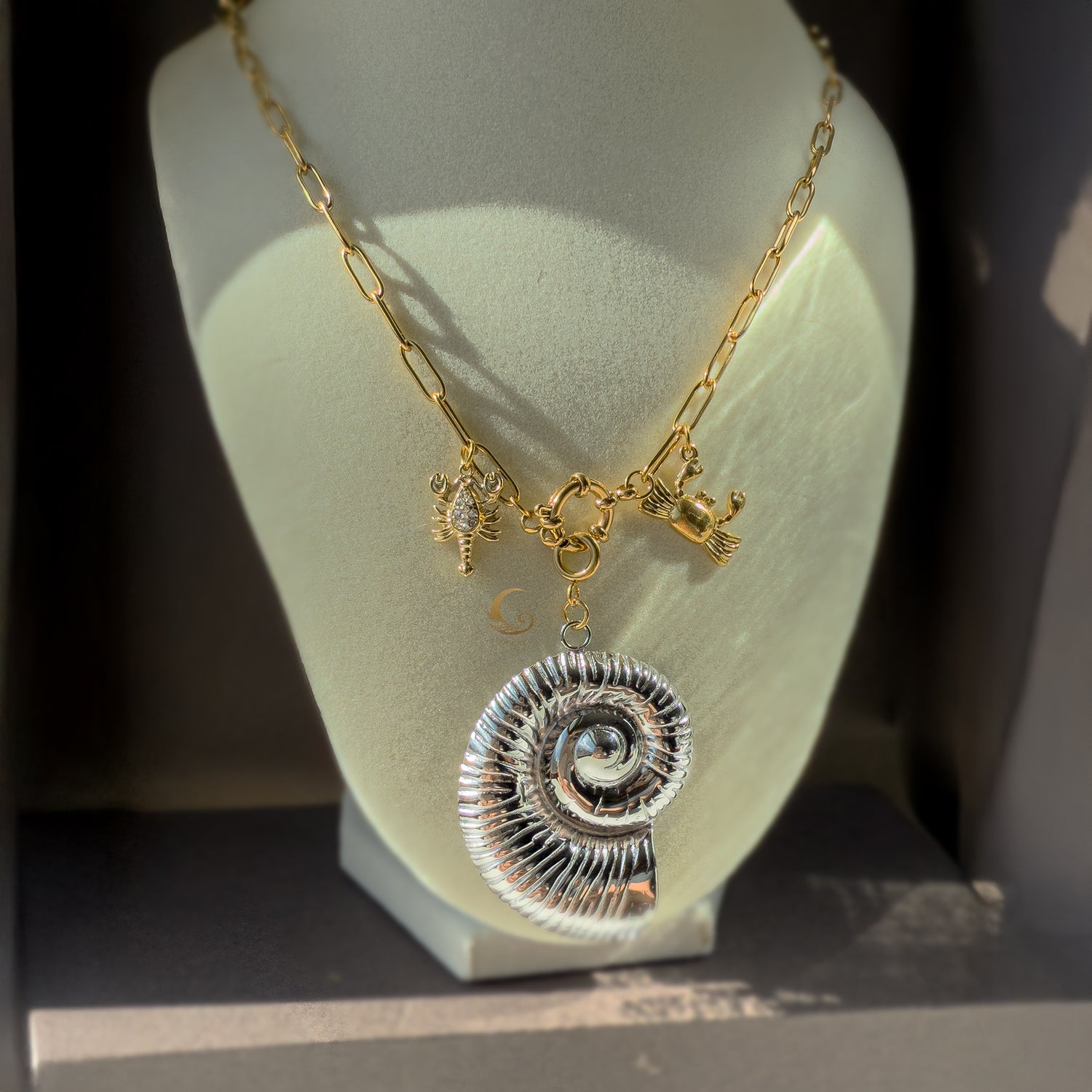 Nerida shell necklace displayed on stand with front toggle clasp and sea creature charms