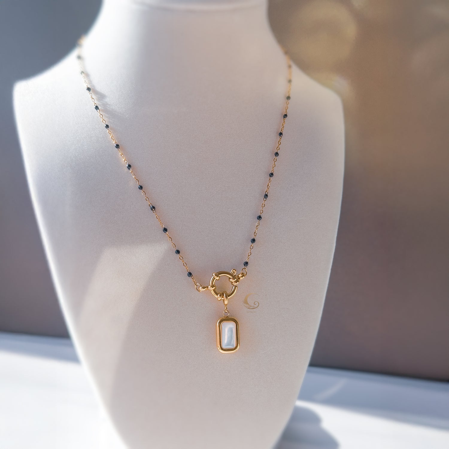Full view of the Nerina necklace displayed on a white bust, showing the elegant shape and pendant placement