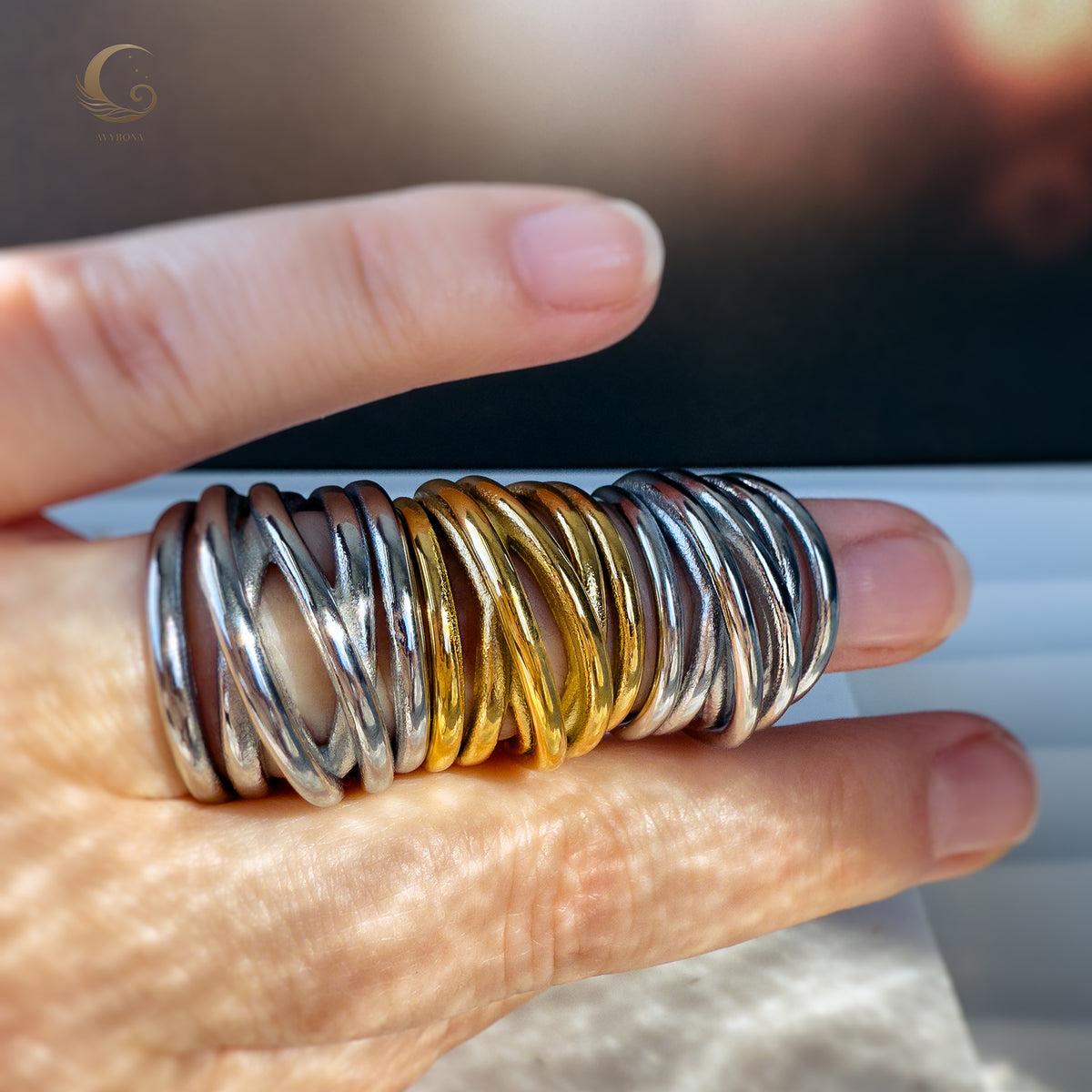 Multiple Branch Rings in gold and silver worn on fingers, highlighting their bold intertwined design and shine.