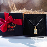 Selara tarot moon necklace in 18K gold plated stainless steel presented in Avyrona signature black jewelry box with red ribbon — celestial gift-ready packaging.