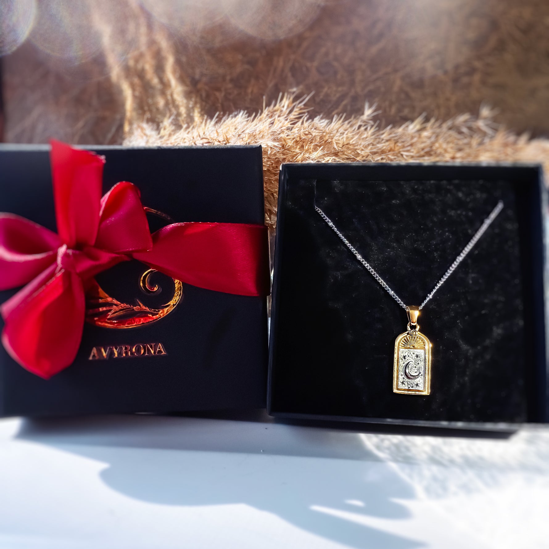 Selara tarot moon necklace in 18K gold plated stainless steel presented in Avyrona signature black jewelry box with red ribbon — celestial gift-ready packaging.