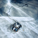 Silver flower necklace with pearl glowing under soft water-reflected light