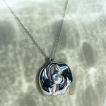 Front-facing view of the silver flower necklace on cream background