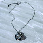 Silver stainless steel necklace fully extended on white surface