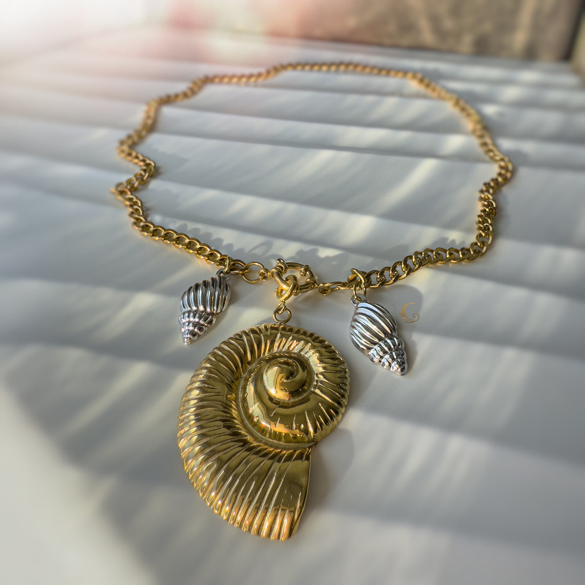 The Thalassa necklace displayed in a circular shape, showcasing the Cuban chain and symmetrical shell arrangement.