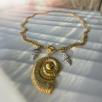 The Thalassa necklace displayed in a circular shape, showcasing the Cuban chain and symmetrical shell arrangement.