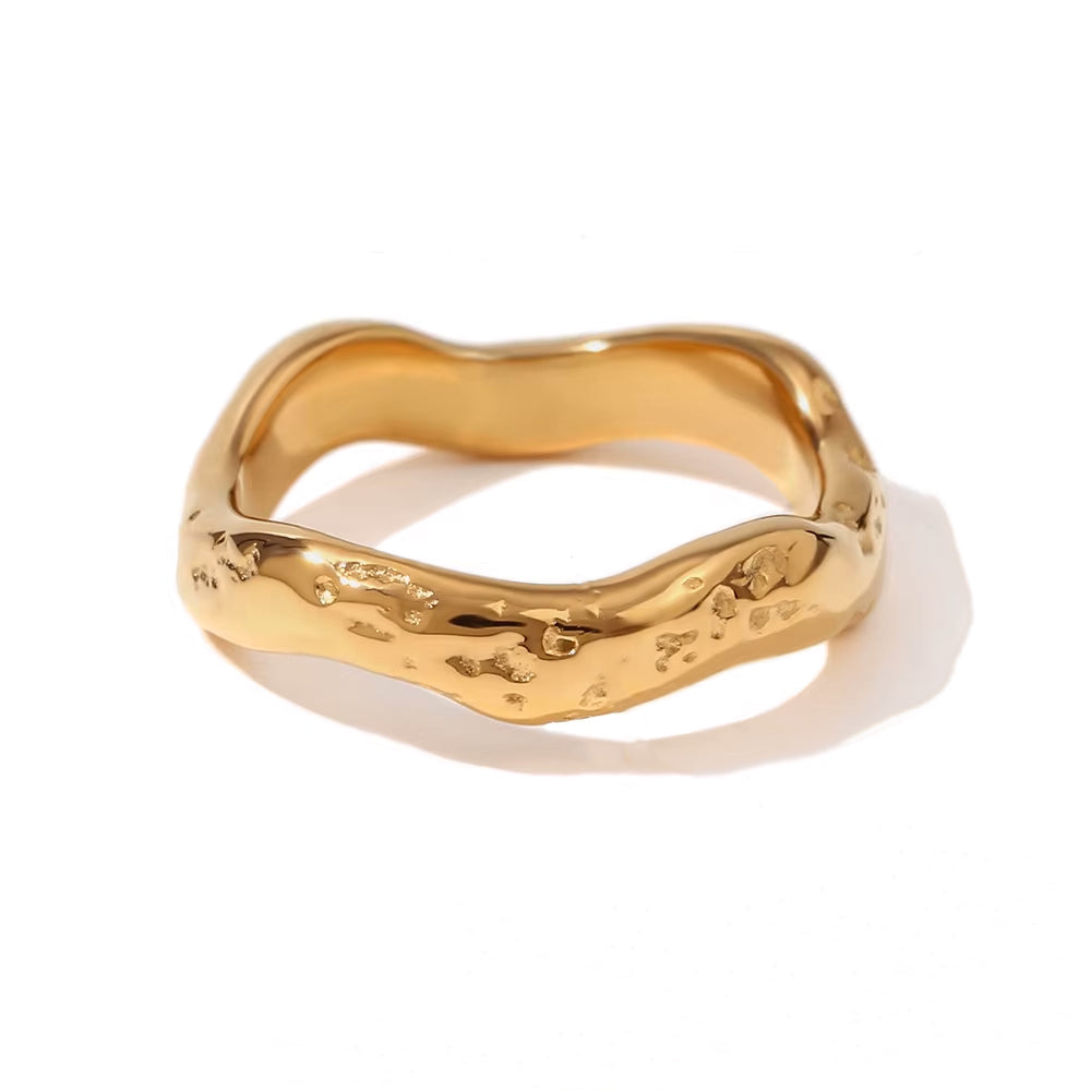 Solo product image of the Wave ring in shiny gold, capturing its textured wave-like form.