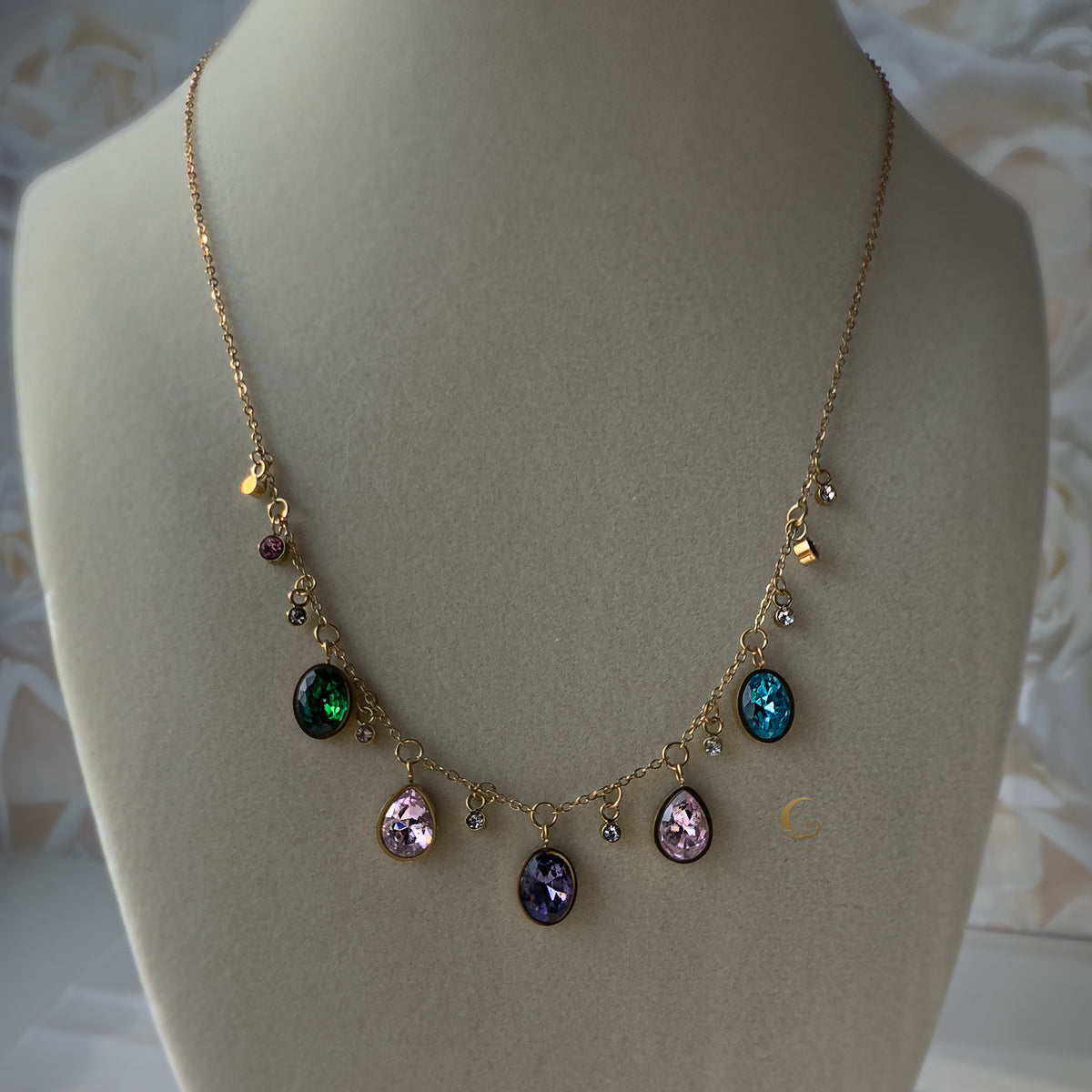 Zaria charm necklace displayed on beige bust showing full crystal layout