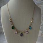 Zaria charm necklace displayed on beige bust showing full crystal layout